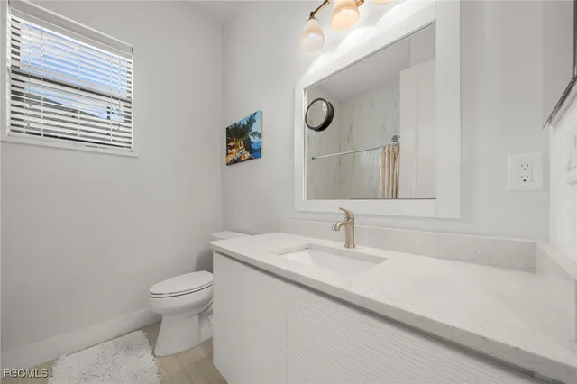 a bathroom with a sink a toilet and mirror