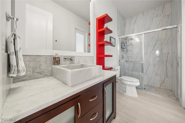 a bathroom with a sink a toilet and shower