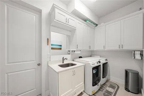 a utility room with sink dryer and washer