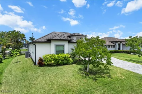 a view of a house with a yard and tree s