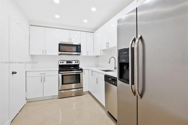 a kitchen with stainless steel appliances a refrigerator sink and cabinets
