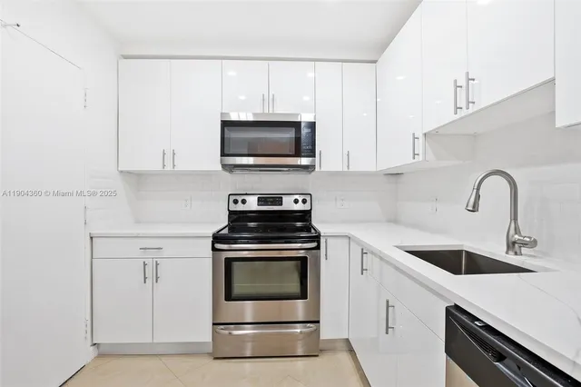 a kitchen with white cabinets stainless steel appliances and sink