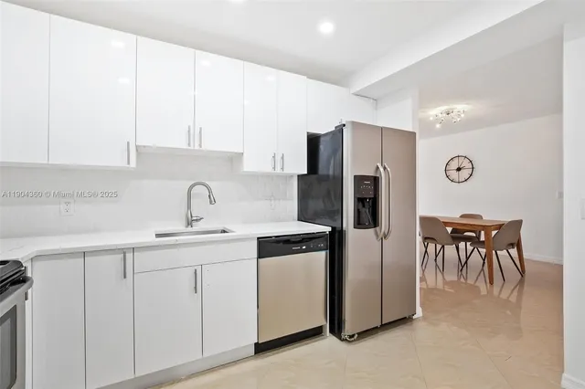 a kitchen with stainless steel appliances granite countertop a refrigerator and a sink