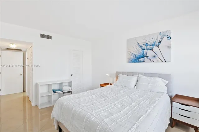 a bedroom with a bed and a painting on the wall