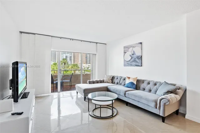 a living room with furniture flat screen tv and a large window