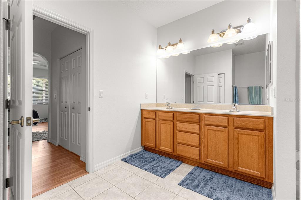 9317 Southwest 94th Loop Ocala, FL 34481 - Photo 22 of 40 a spacious bathroom with a granite countertop sink a mirror and a vanity