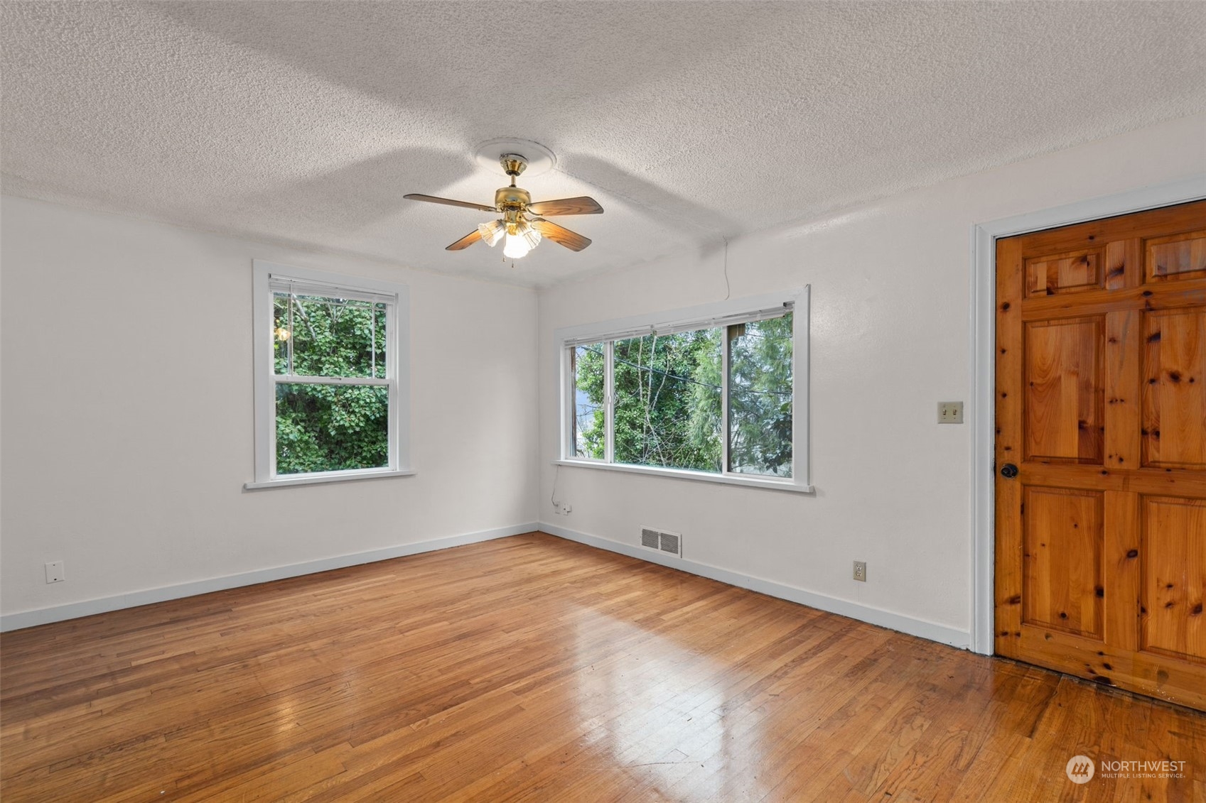666 Sunset Boulevard Northeast Renton, WA 98056 - Photo 5 of 39 a view of an empty room with a window and wooden floor