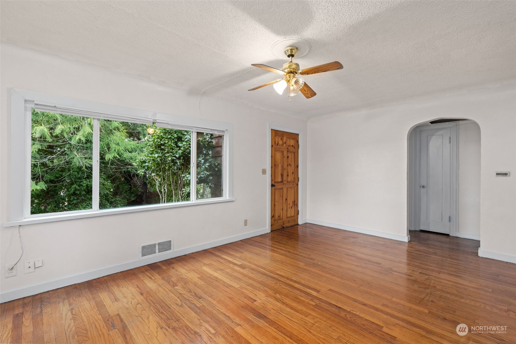 666 Sunset Boulevard Northeast Renton, WA 98056 - Photo 6 of 39 a view of an empty room with wooden floor and a window