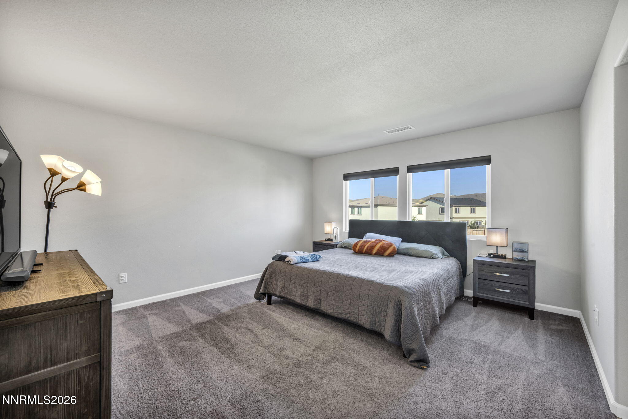 8850 Finnsech Drive Reno, NV 89506 - Photo 11 of 56 a bedroom with a bed and a flat tv screen on dresser