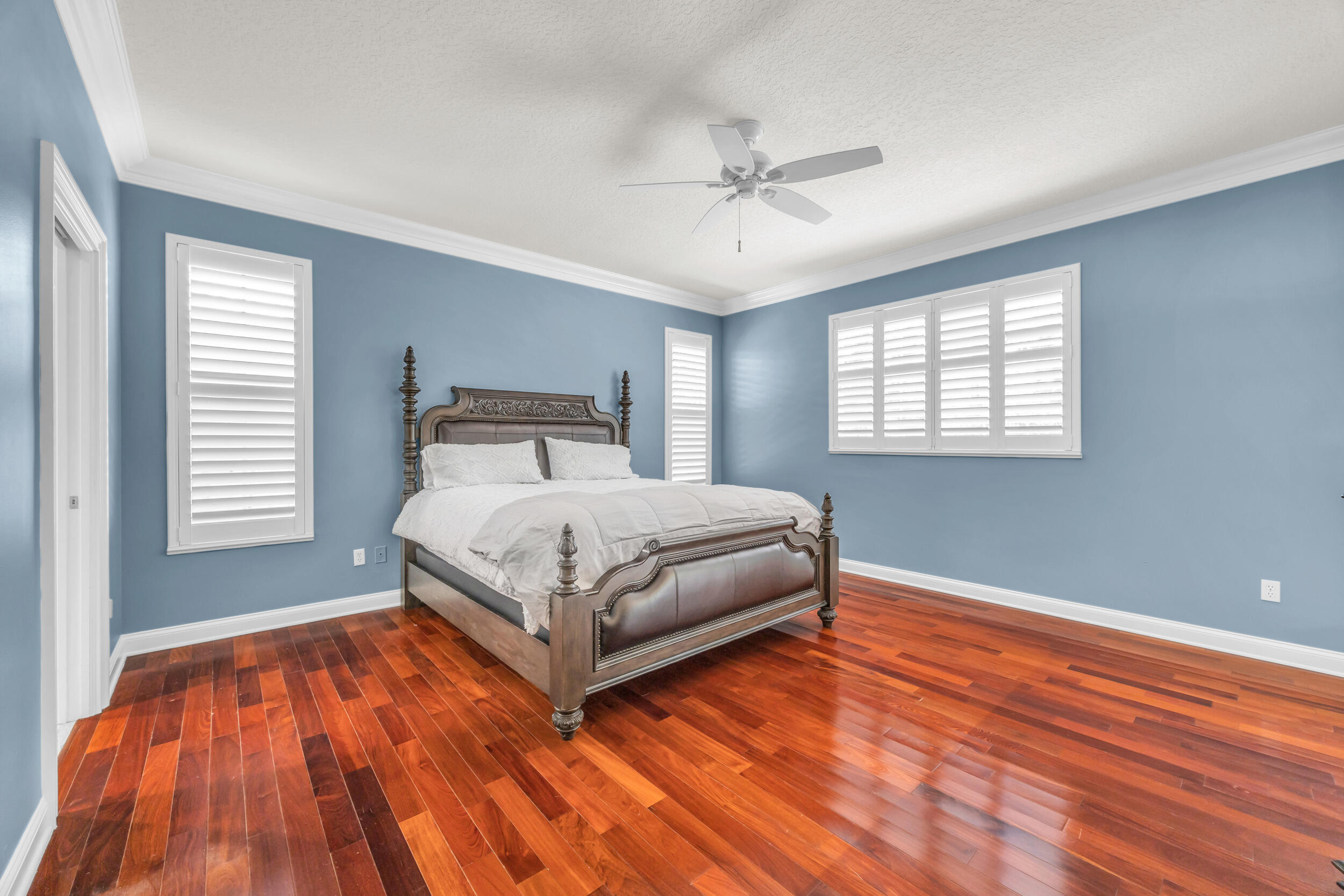 148 Cypress Cove Jupiter, FL 33458 - Photo 16 of 53 a bedroom with a bed and wooden floor