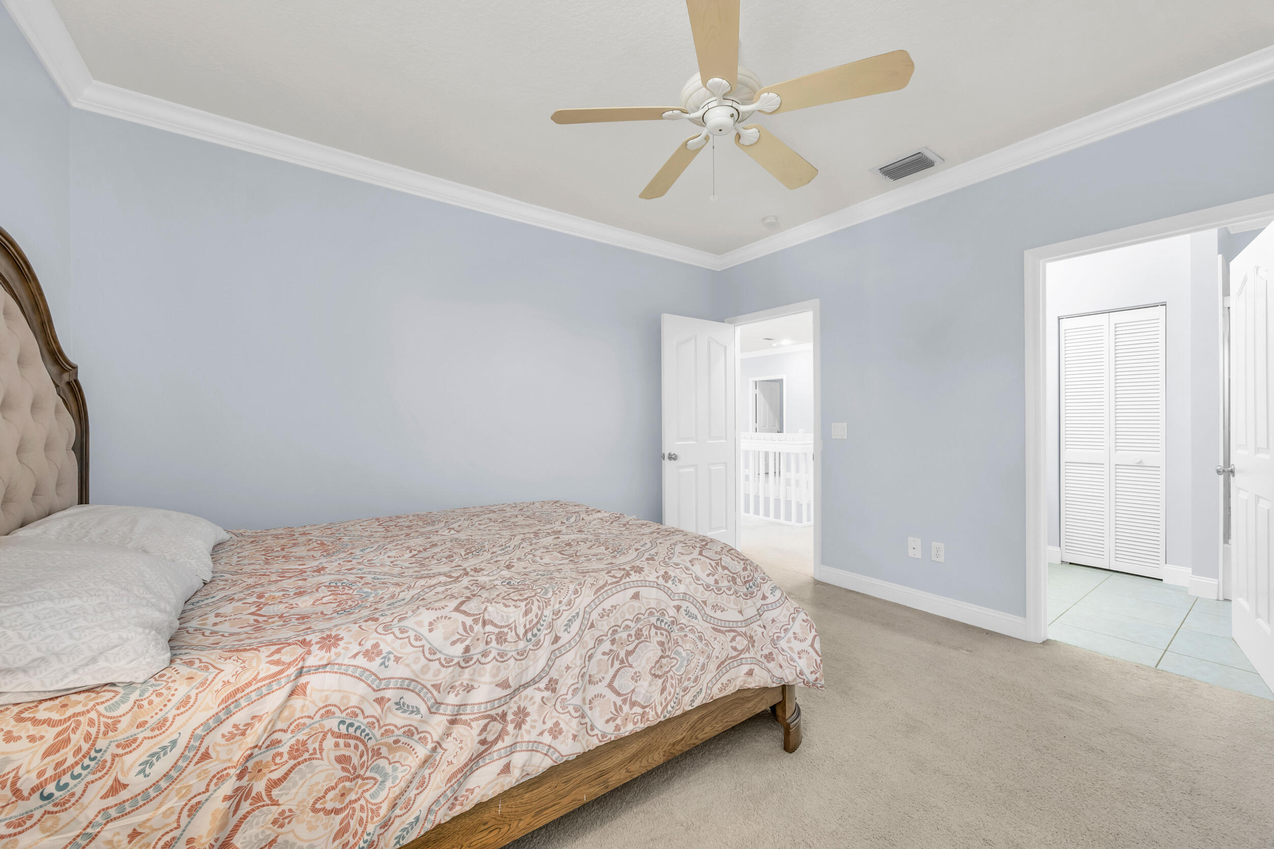 148 Cypress Cove Jupiter, FL 33458 - Photo 35 of 53 a bedroom with a bed ceiling fan and a wooden floor