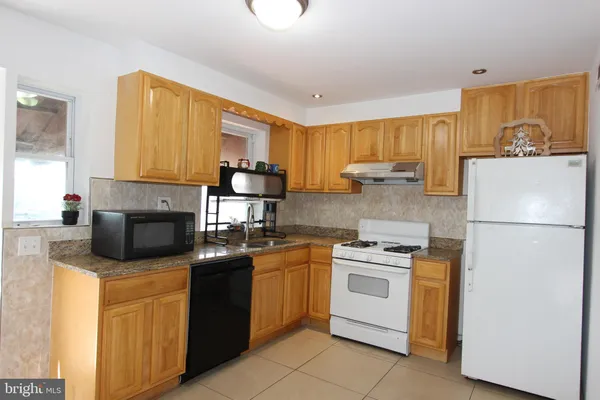 a kitchen with stainless steel appliances granite countertop a stove a sink dishwasher and a refrigerator