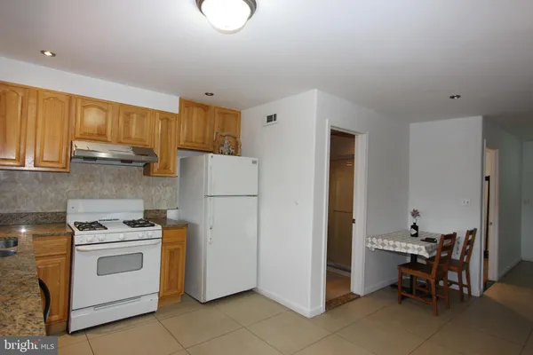 a kitchen with a white stove top oven and cabinets
