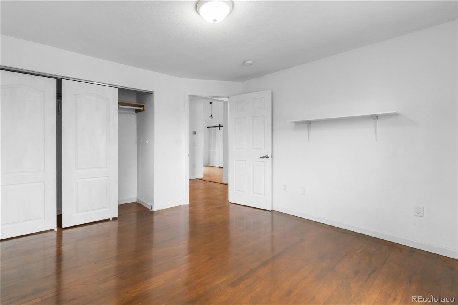 7010 West 44th Avenue Wheat Ridge, CO 80033 - Photo 22 of 31 a view of an empty room with wooden floor and a window