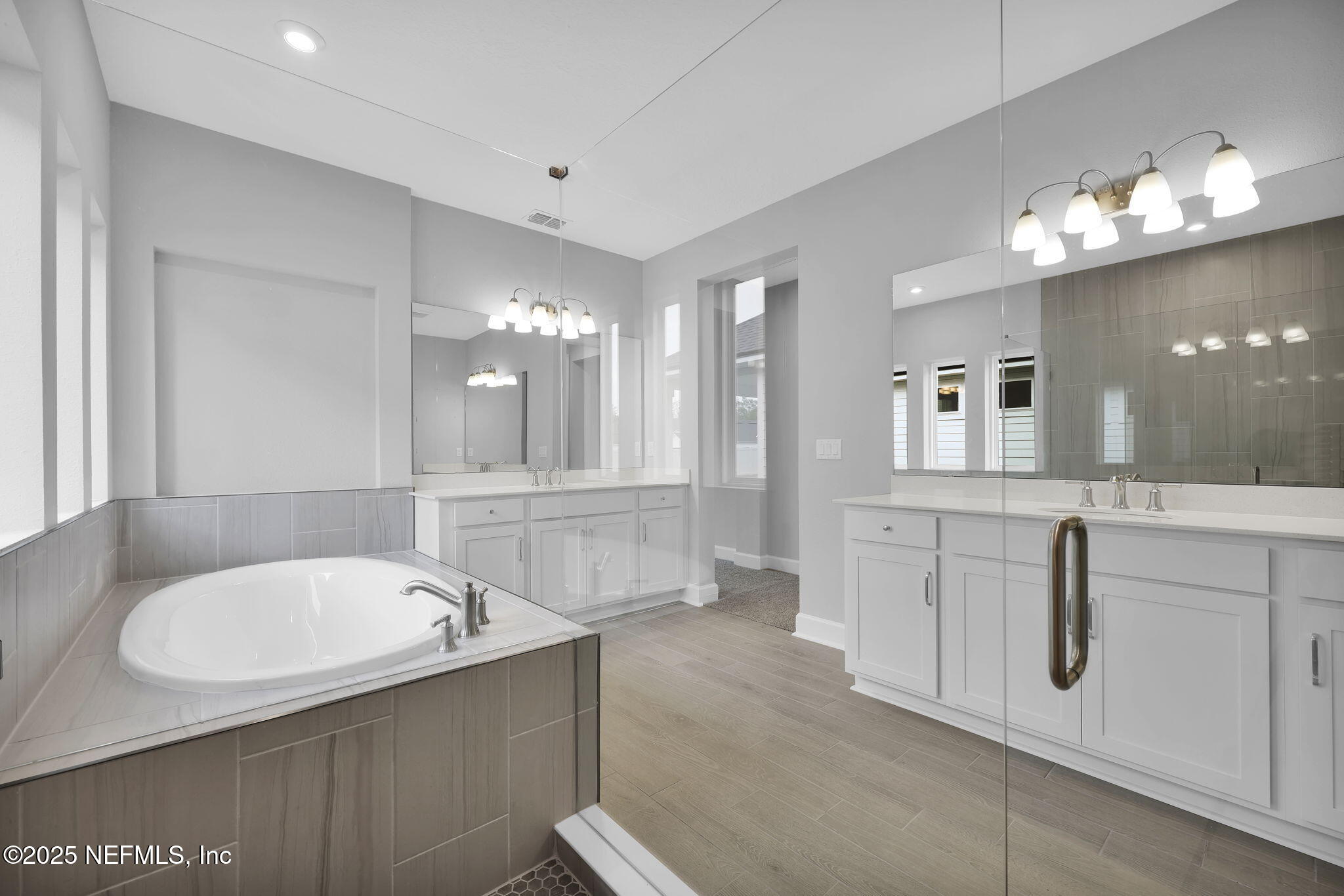 39 Greylock Lane St. Augustine, FL 32092 - Photo 43 of 54 a bathroom with a tub a double vanity sink and a mirror