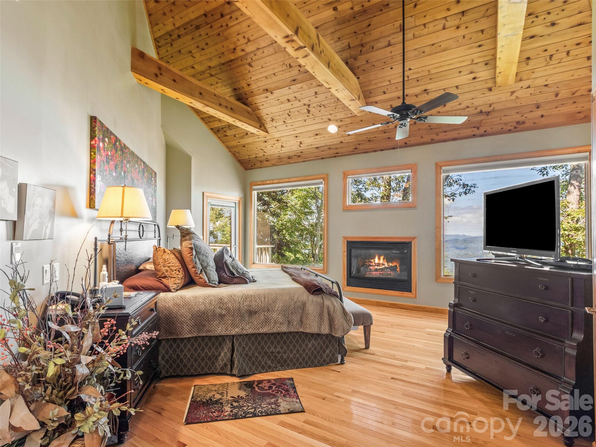 350 Ball Camp Road Burnsville, NC 28714 - Photo 33 of 44 a bedroom with a bed a fireplace and a flat tv screen