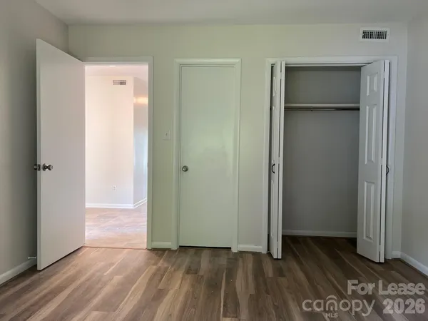 an empty room with wooden floor and closet