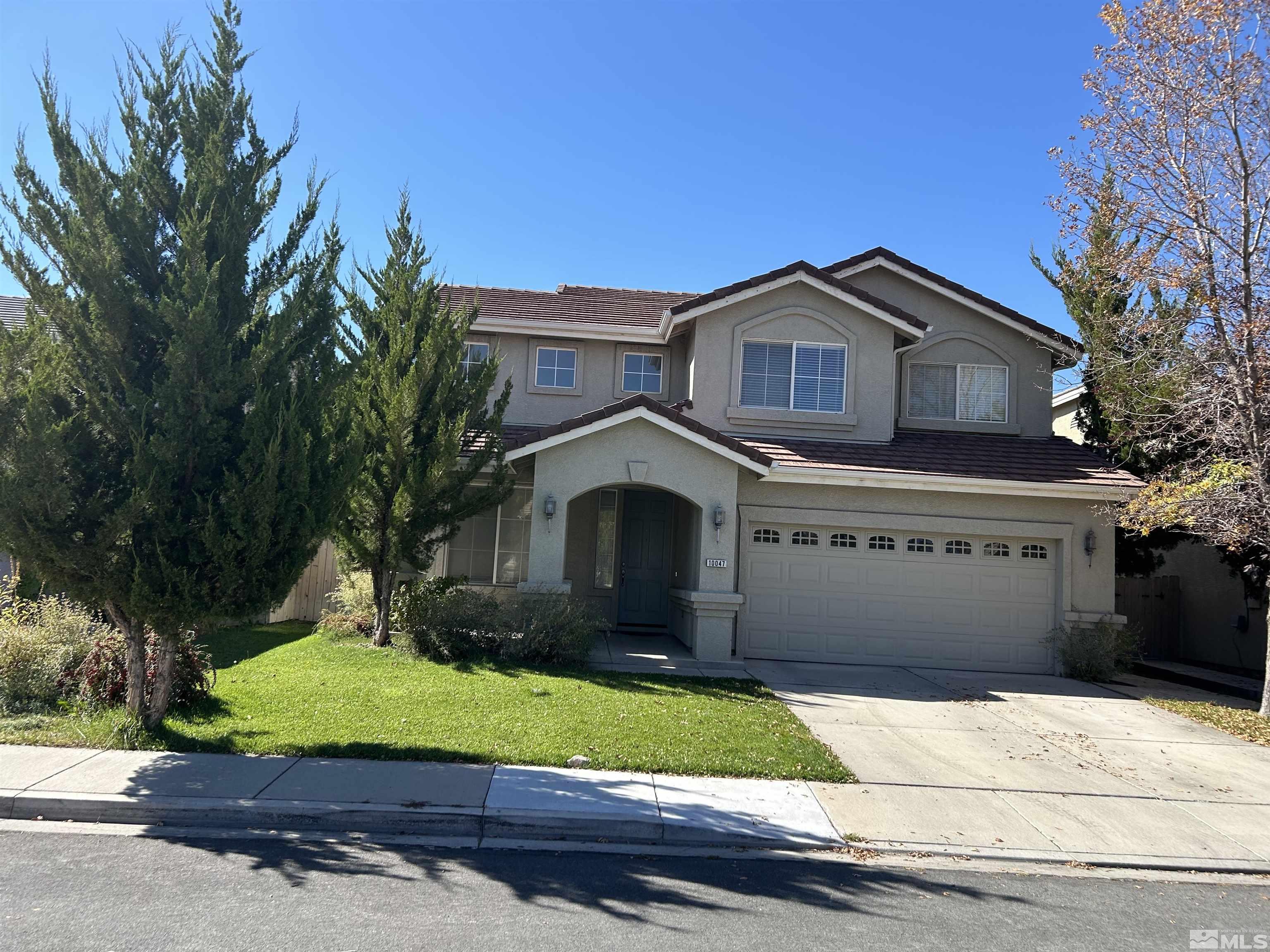 10047 Silver Star Drive Reno, NV 89521 - Photo 2 of 26 a front view of a house with a yard and garage