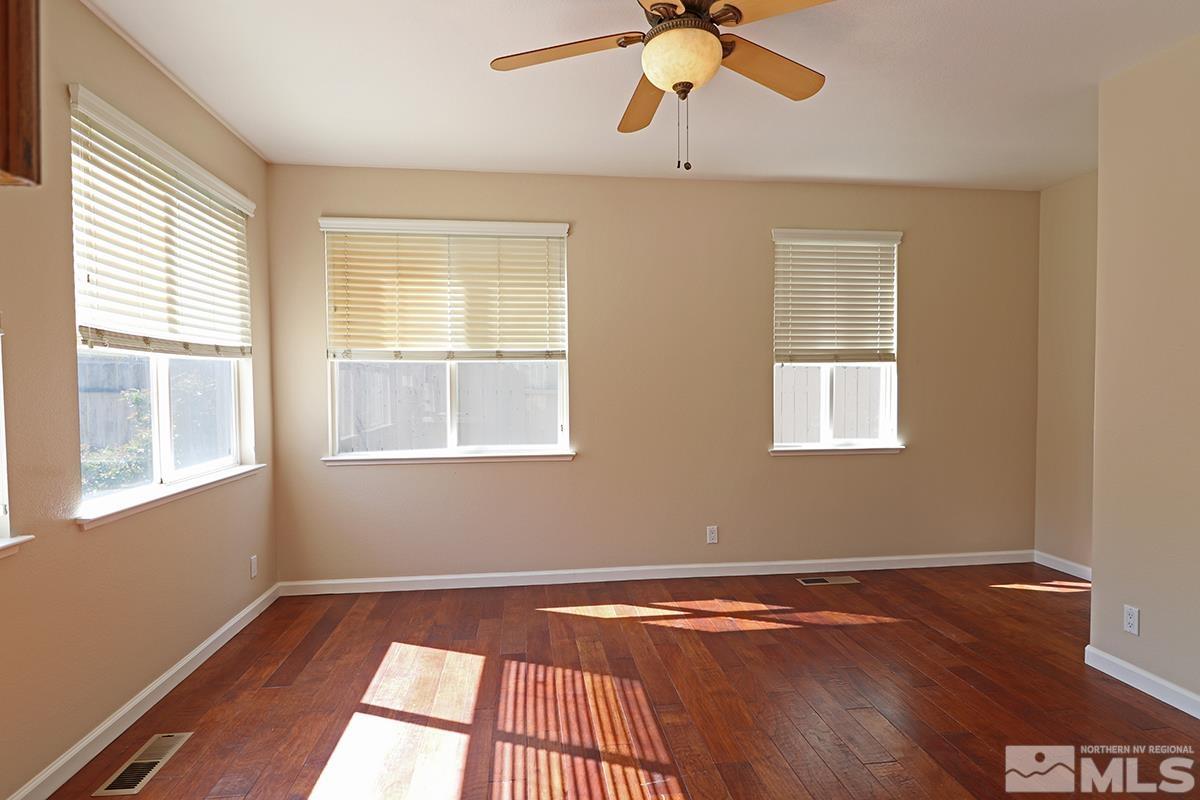 10047 Silver Star Drive Reno, NV 89521 - Photo 6 of 26 a view of an empty room with wooden floor and a window