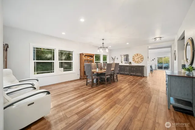 a spacious bedroom with a bed and a flat tv screen on dresser