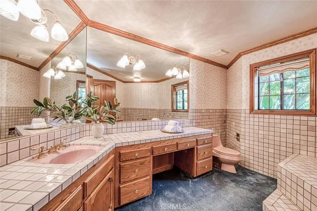 a spacious bathroom with a sink a mirror a bathtub and next to a window