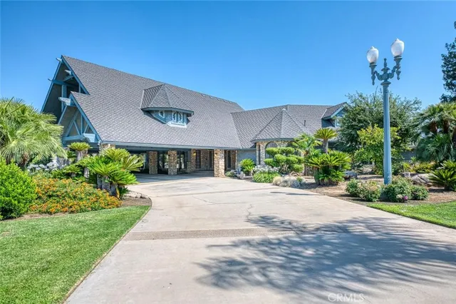 a view of a house with a yard and potted plants