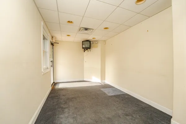 a large white kitchen with a sink and a wooden floor