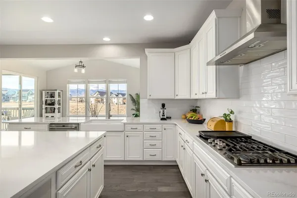 a kitchen with white cabinets a stove and a window