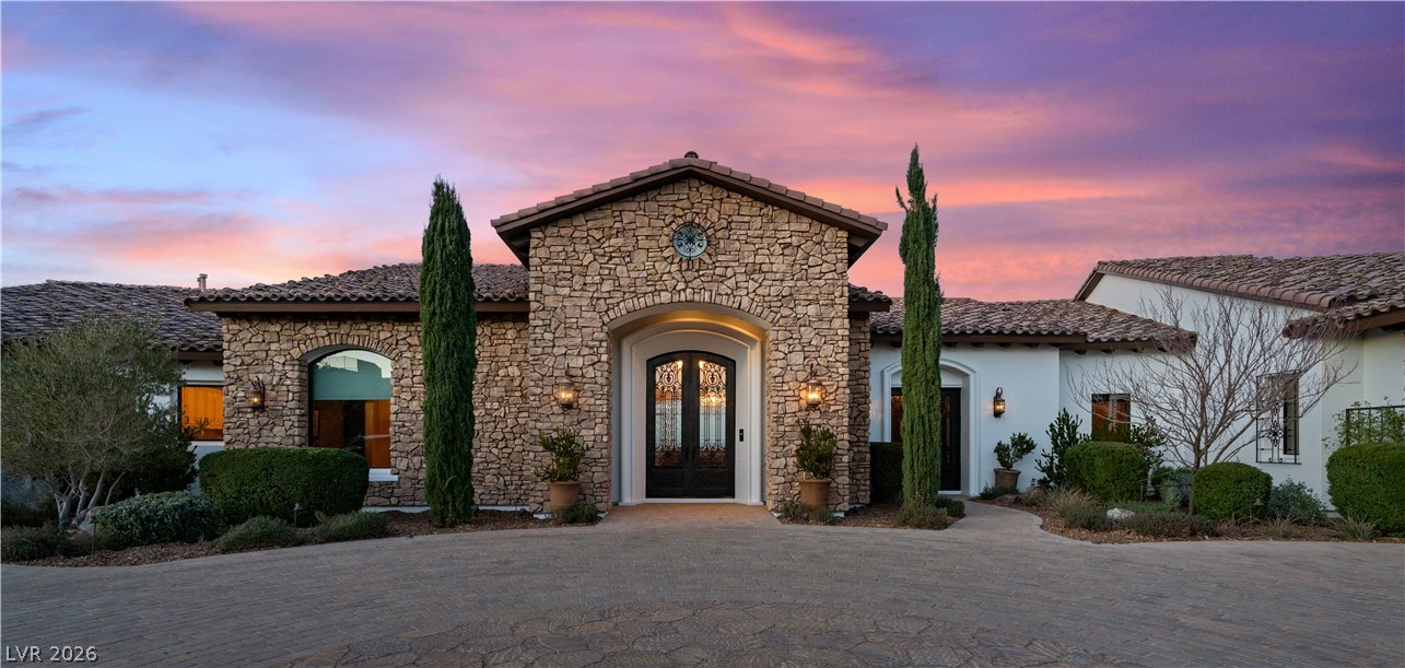 1123 Christian Road Henderson, NV 89002 - Photo 4 of 94 Mediterranean-inspired facade with stone accents and a terracotta roofline creates inviting curb appeal.