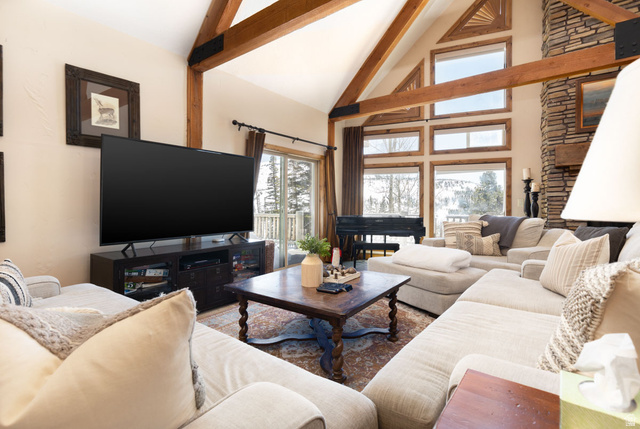 382 Ridgeview Street, Unit 8 & 9 Brian Head, UT 84719 - Photo 32 of 52 Living area featuring vaulted ceilings with exposed wood beams, a stone fireplace, large picture windows, and a sliding glass door leading to a deck