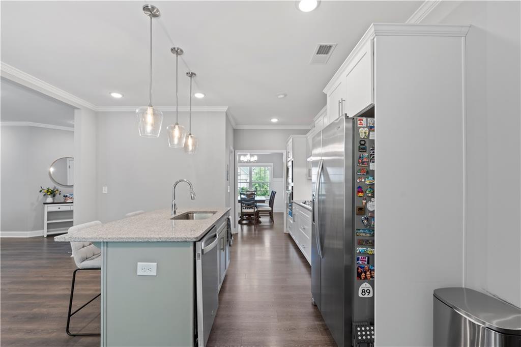 540 Glen Abbey Circle Mableton, GA 30126 - Photo 11 of 47 a kitchen with stainless steel appliances granite countertop a refrigerator a sink dishwasher a oven a dining table and chairs with wooden floor