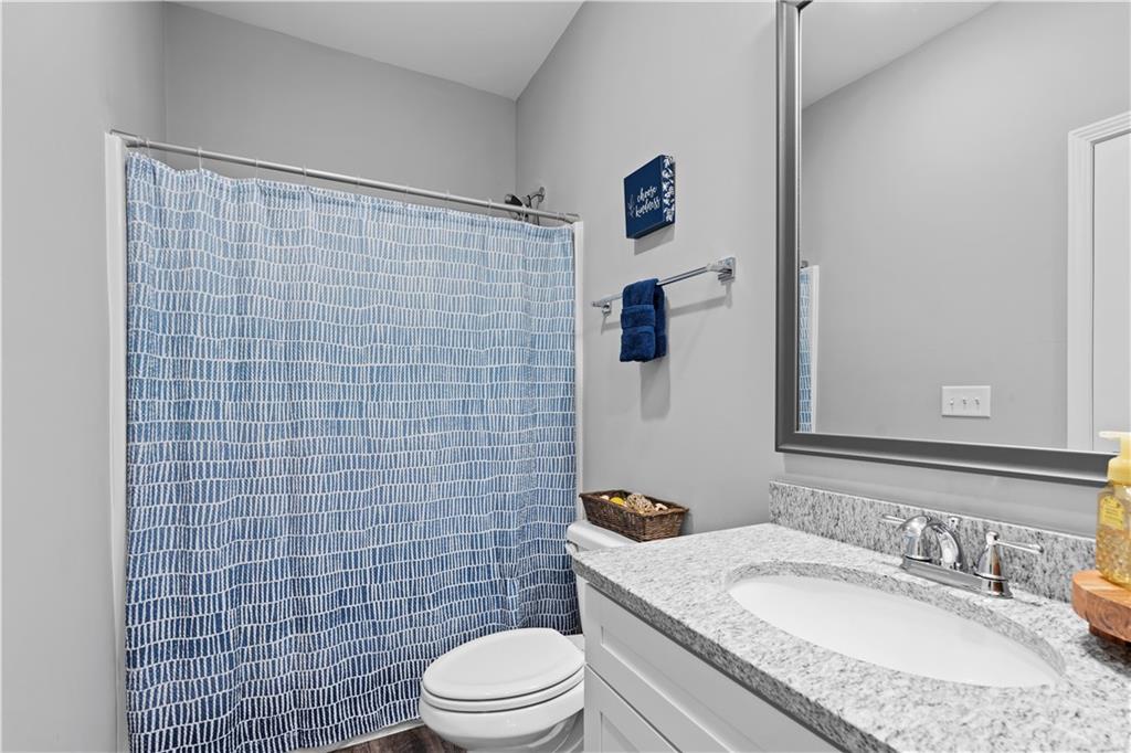 540 Glen Abbey Circle Mableton, GA 30126 - Photo 19 of 47 a bathroom with a granite countertop toilet sink and mirror