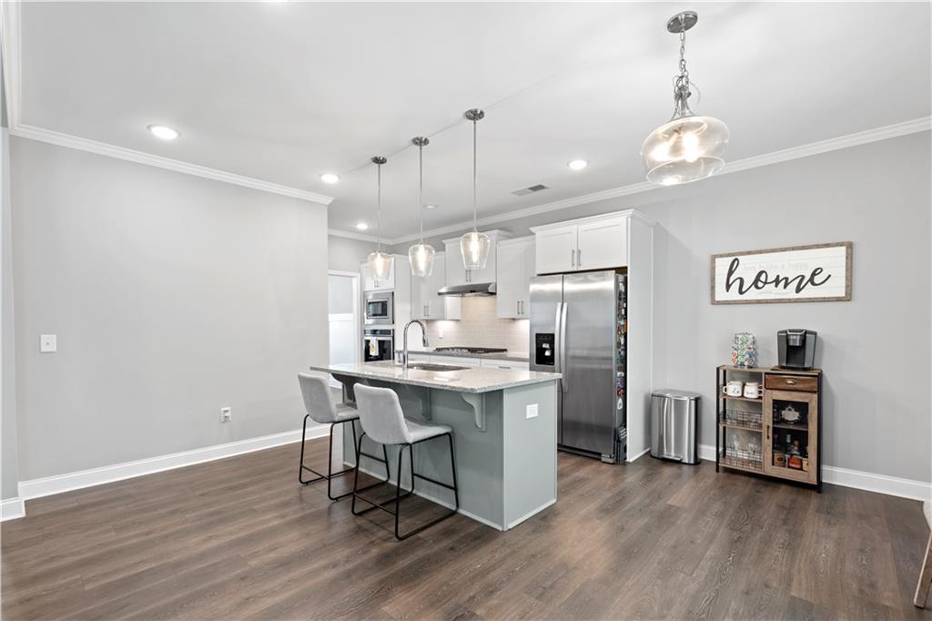 540 Glen Abbey Circle Mableton, GA 30126 - Photo 8 of 47 a open kitchen with stainless steel appliances granite countertop a refrigerator a stove a sink dishwasher and a dining table with wooden floor