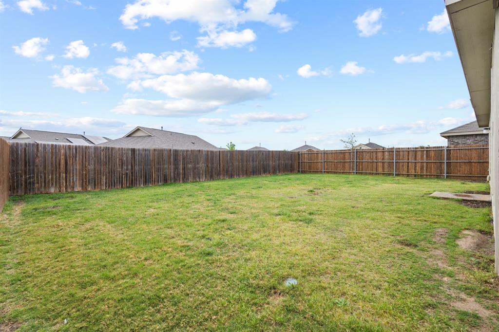 2604 Spring Time Drive Ennis, TX 75119 - Photo 20 of 21 a view of a backyard with grass & fence