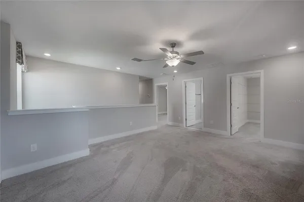 a view of an empty room with a ceiling fan