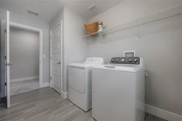 a utility room with wooden floor washer and dryer