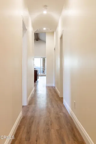 a view of a hallway with wooden floor and a living room