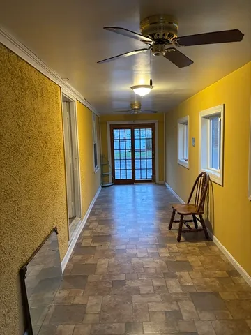 a furnished livingroom with a chair and wooden floor