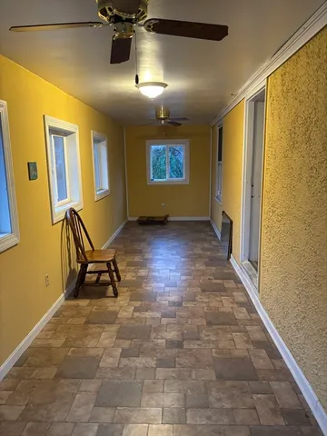 a view of a hallway with chairs and painted walls