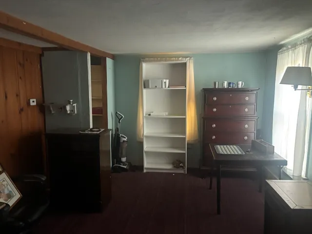 a view of an empty room with wooden floor and windows