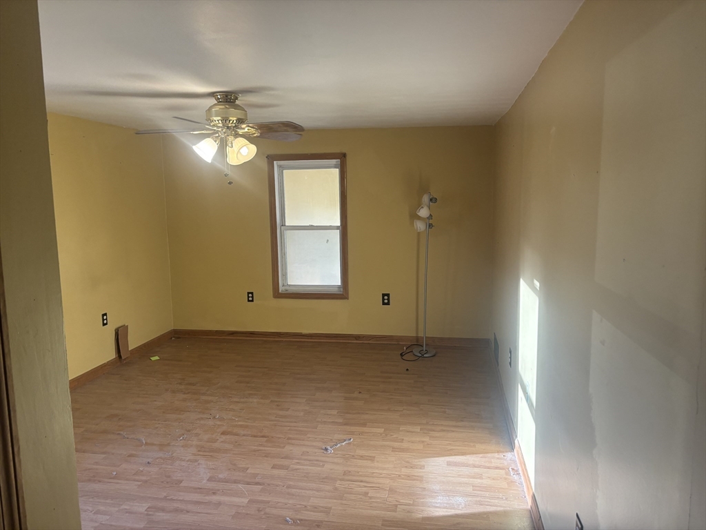 10 Cottage Street Belchertown, MA 01007 - Photo 26 of 40 an empty room with a chandelier fan and windows