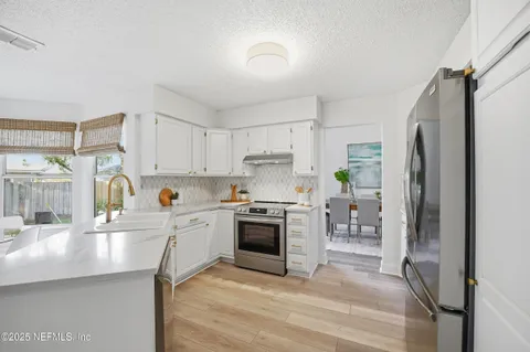a kitchen with granite countertop a refrigerator stove and sink