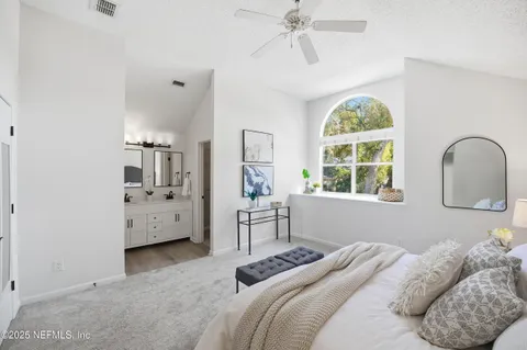 a bedroom with a bed and a large window
