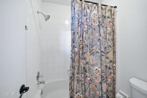 a bathroom with a shower curtain and a toilet