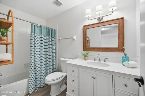 a bathroom with a granite countertop toilet sink and mirror