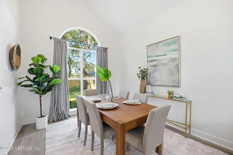 a dining room with furniture a potted plant and a chandelier