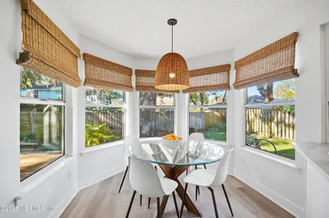 a dining room with furniture a chandelier and wooden floor
