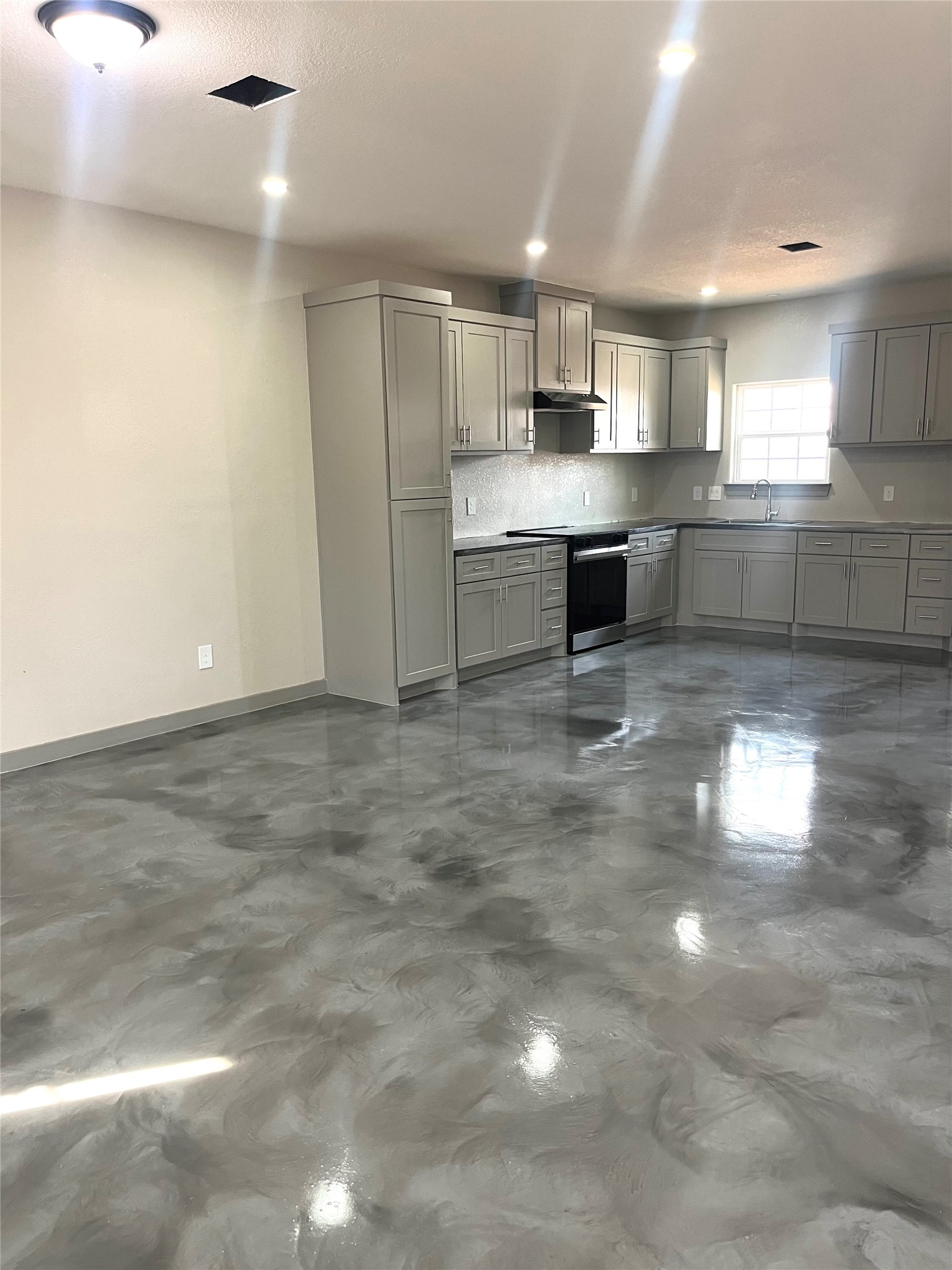 17539 Reno Road Conroe, TX 77306 - Photo 6 of 19 a living room with stainless steel appliances kitchen island granite countertop a stove a sink a refrigerator and cabinets
