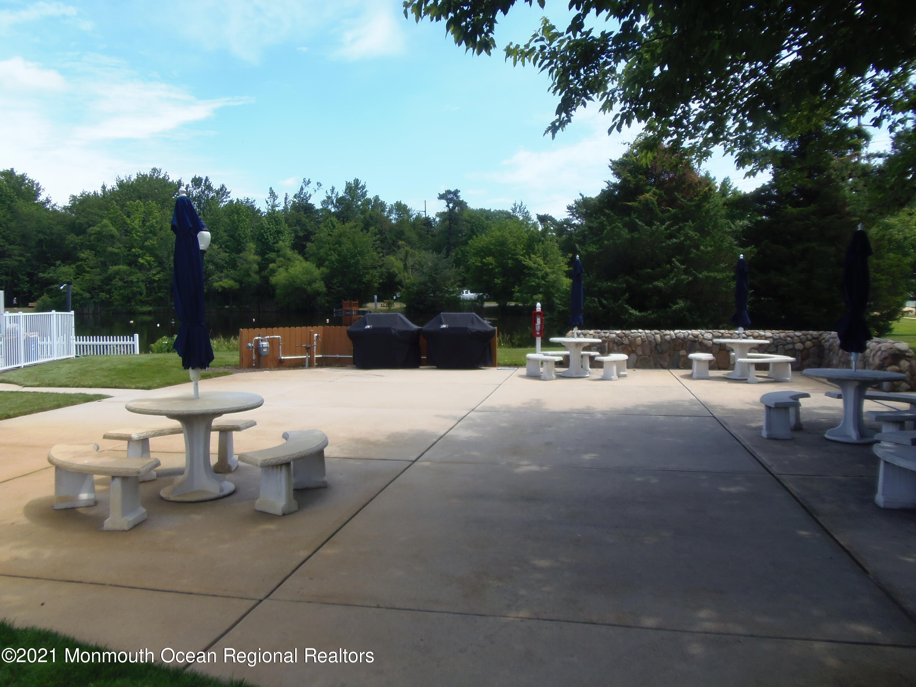 40 Red Hill Road Manchester Township, NJ 08759 - Photo 30 of 33 a view of a patio with dining table and chairs with a fire pit