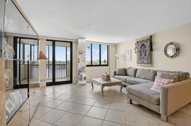 a living room with furniture and a dining table with rug